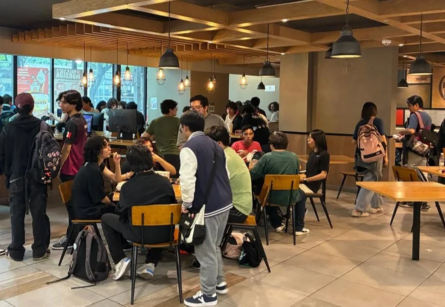 Jugadores y asistentes reunidos en un local durante un evento de KOA